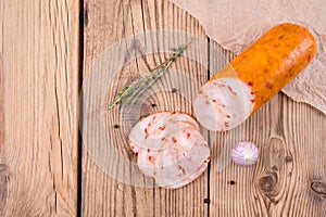 Chicken roll with paprika lies on an old wooden table with a sprig of thyme and garlic. top view. background for design