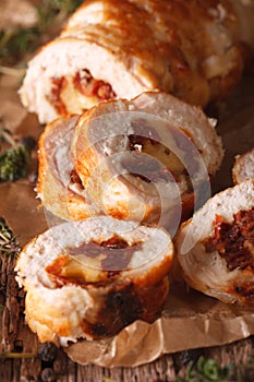 Chicken roll stuffed with cheese and sun-dried tomatoes close-up. vertical