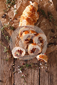 Chicken roll stuffed with cheese and sun-dried tomatoes close-up. Vertical top view