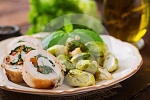 Chicken rolls with greens, garnished with stewed Brussels sprouts,