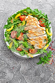 Chicken salad. Meat salad with fresh tomato, sweet pepper, arugula and grilled chicken breast. Chicken fillet with fresh vegetable