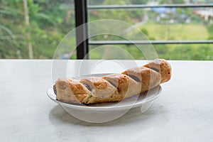 Chicken sausage bun in white dish on table