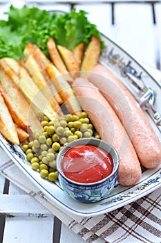 Chicken sausages with the fried potato, catchup and fresh lettuce