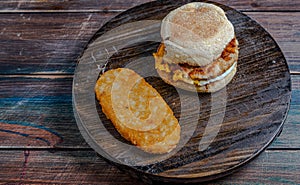 Chicken saussage mcmuffin with egg, and golden brown and crispy, hashbrowns photo