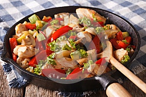 Chicken saute with mushrooms, peppers and zucchini closeup on a