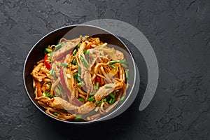 Chicken Schezwan Noodles or Hakka or Chow Mein in black bowl at dark background. Schezwan Noodles is indo-chinese cuisine hot dish