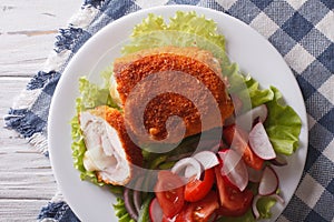 Chicken schnitzel cordon bleu and a salad close-up. Horizontal t