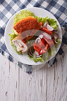 Chicken schnitzel cordon bleu and a salad. vertical top view