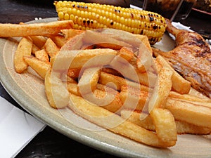 Chicken and seasoned french fries on a plate