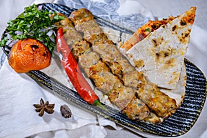 Chicken seekh kabab meat kebab with pita bread, tomato and onion served in dish isolated on food table top view of middle east