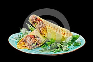 Chicken shawarma in cheese pita lies on a plate on a black isolated background