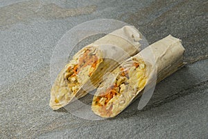 Chicken Shawarma wrapped in lavash on stone background. Greek Gyros roll. Turkish grilled donner