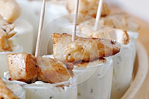 Chicken skewers with dip in glasses, party snacks on cold buffet