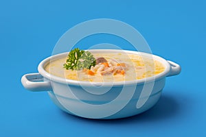 Chicken soup bowl close-up, isolated on a blue background