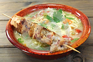 Chicken soup with chicken skewers and noodles