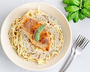 Chicken Spaghetti Pasta with Fresh Basil Leaves on White Background Top Down Horizontal Photo