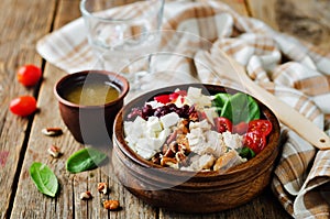 Chicken spinach apple tomato goat cheese salad in a bowl