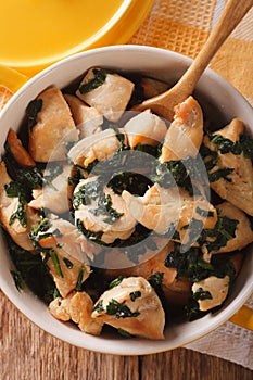 Chicken with spinach in a pan close-up on the table. Vertical to