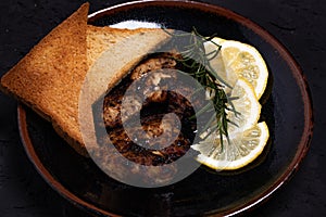 Chicken Steak with Black Pepper Garnish with Lemon and Rosemary. Dark Tone