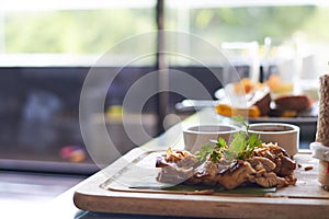 Chicken steak with dip on banana leaf and wood plate in thai style