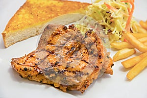 Chicken steak served with french fries, salads and bread