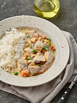 Chicken stew with vegetables and mushroom cream sauce. Tender chicken fillet in a creamy mushroom sauce with rice and green peas