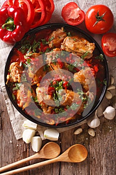 Chicken stew with vegetables on a table close-up. vertical top v photo