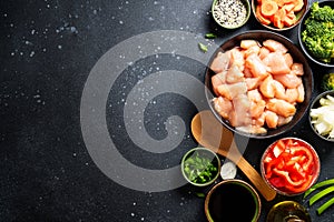 Chicken stir fry with vegetables cooking ingredients at black background.