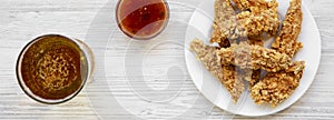 Chicken strips with sauce and cold beer over white wooden background, top view. From above, overhead, flat lay.