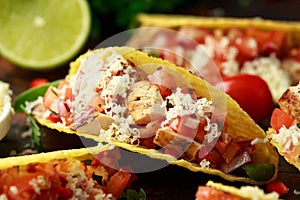 Chicken tacos with salsa, cheese and corn tortila