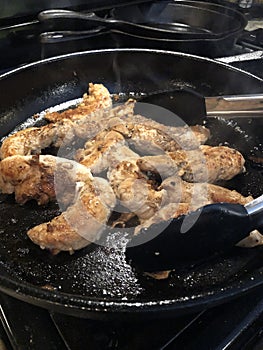 Chicken tenderloins cooked in cast iron pan