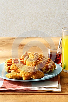 Chicken tenders with waffles and a glass of orange juice