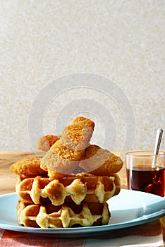 Chicken tenders and waffles with maple syrup