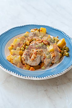 Chicken Thighs with Potato, Carrot and Green Peas served in Plate for One Portion photo