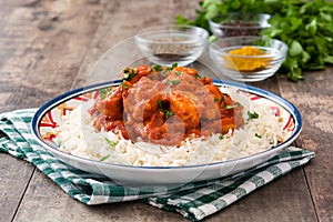 Chicken tikka masala with basmati rice on wood