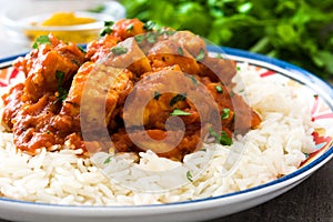 Chicken tikka masala with basmati rice on wood