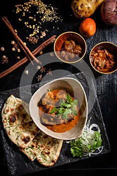 Chicken tikka masala spicy curry meat food Butter chicken with rice and naan bread on dark background close-up