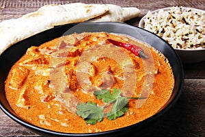 Chicken tikka masala spicy curry meat food in pot with rice and naan bread. indian food