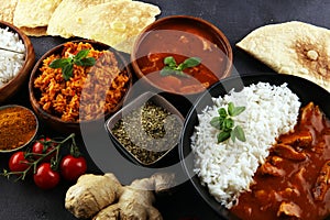 Chicken tikka masala spicy curry meat food in pot with rice and naan bread. indian food on table