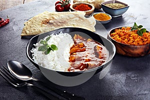 Chicken tikka masala spicy curry meat food in pot with rice and naan bread. indian food on table