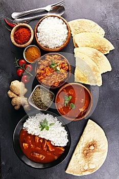 Chicken tikka masala spicy curry meat food in pot with rice and naan bread. indian food on table