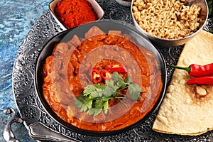 Chicken tikka masala spicy curry meat food in pot with rice and naan bread. indian food on table