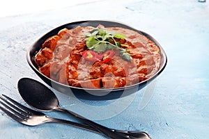 Chicken tikka masala spicy curry meat food in pot with rice and naan bread. indian food on table