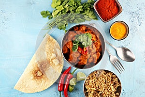 Chicken tikka masala spicy curry meat food in pot with rice and naan bread. indian food on table