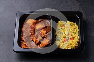 Chicken Tikka Masala and Turmeric Rice Indian cuisine in black box