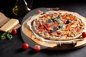 Chicken tomato pepper pizza with olives and basil