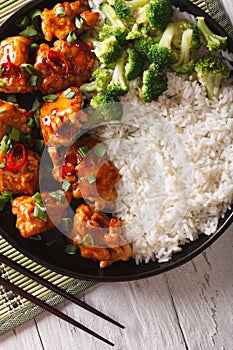 Chicken tso in sauce with rice and broccoli closeup. vertical to