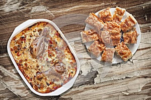 Chicken Vegetable Stew In Baking Pan With Plateful Of Gibanica Crumpled Cheese Pie Slices On Old Cracked Flaky Garden Table