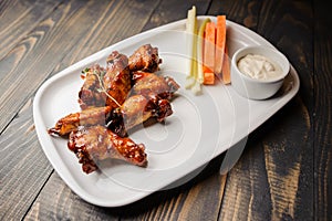 Chicken wings baked with carrot and celery close up