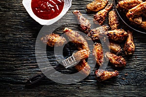 Chicken wings barbeque in a cast iron baking dish with BBQ - Top of view
